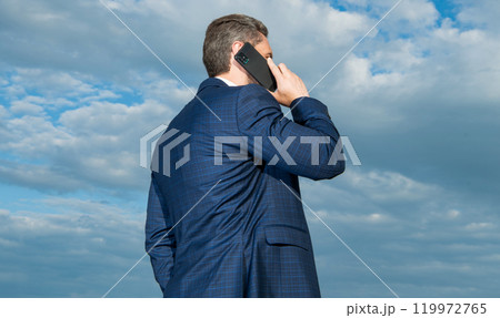 back view photo of man having phone talk. man has phone talk on sky background. 119972765