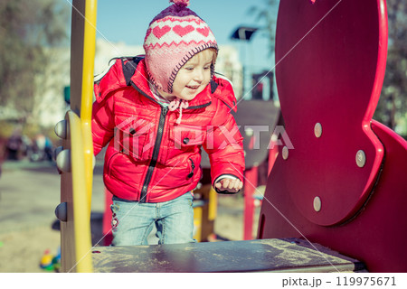 little cute girl playing at the playground in autumn little cute girl playing at the playground in autumn 119975671