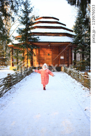 a child joyfully running toward a cozy home, surrounded by a beautiful winter landscape 119976033