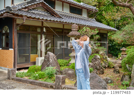 古民家の前で頭を抱える女性　空き家　田舎　相続 119977483