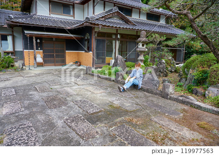古民家のお庭にする女性　田舎暮らし　 119977563
