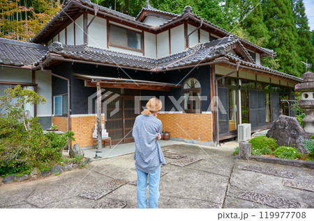 古民家の前で首をかしげる女性 空き家 相続 田舎 古民家の前で首をかしげる女性 空き家 相続 田舎 119977708