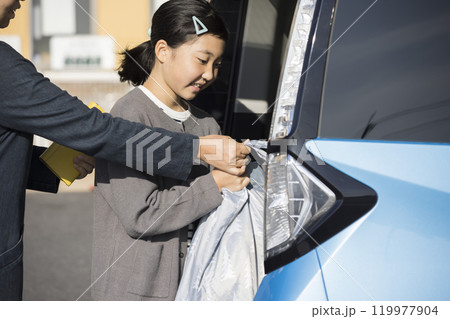 スーパーの駐車場お母さんと一緒に荷物を入れる子供　お手伝いイメージ 119977904
