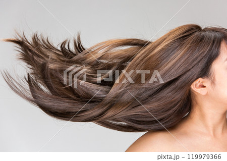 若い女性の艶のあるなびく髪の毛のクローズアップ. 119979366