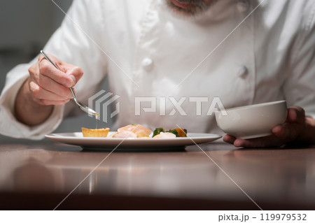 料理の試作をする男性シェフ 119979532