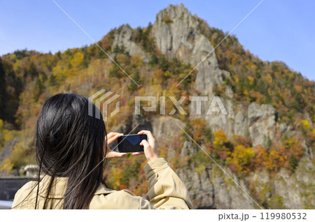 秋の【北海道 豊平峡】を観光する女性 秋の【北海道 豊平峡】を観光する女性 119980532