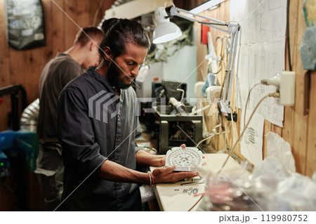 Young male technician opening press mold Young male technician opening press mold 119980752