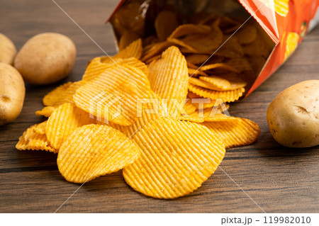 Potato chips, delicious BBQ seasoning spicy for crips, thin slice deep fried snack fast food in open bag. 119982010