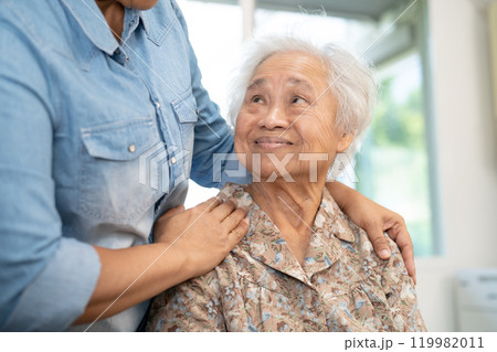 Caregiver help and care Asian senior woman patient with love, encourage and empathy in hospital. 119982011