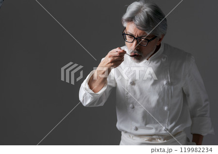 料理の味見をする男性シェフ 料理の味見をする男性シェフ 119982234