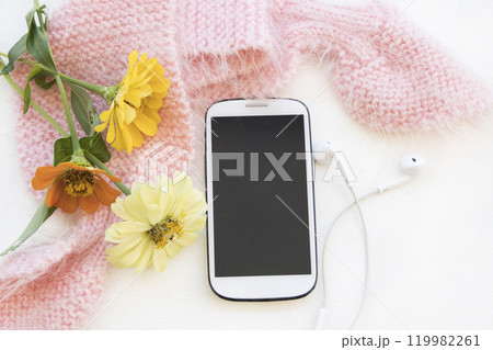 mobile phone, earphone with knitting wool scarf of lifestyle woman in winter  119982261