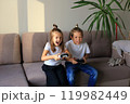 A lively scene of a boy and girl enthusiastically playing video games together at home. they immerse themselves in the gaming experience, highlighting the joy of childhood and the importance of 119982449