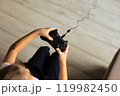 A close-up shot of hands gripping a game controller, showcasing the excitement and intensity of gaming. 119982450