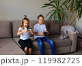 A lively scene of a boy and girl enthusiastically playing video games together at home. they immerse themselves in the gaming experience, highlighting the joy of childhood and the importance of 119982725