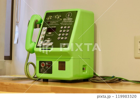 窓際のカウンター上の緑色の公衆電話 119983320