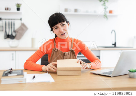 Young woman preparing for online business with packaging on desk 119983902