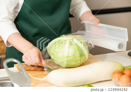 家のキッチンでキャベツにラップをするミドル〜シニア女性 家のキッチンでキャベツにラップをするミドル〜シニア女性 119984292