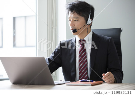ヘッドセットをつけて仕事をする男性 119985131