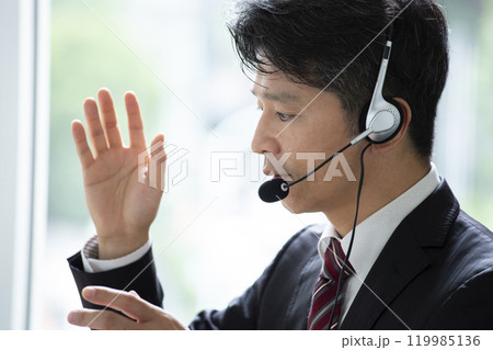 ヘッドセットをつけて仕事をする男性 119985136