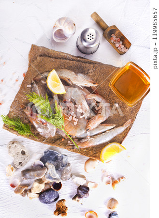 Raw tiger white shrimp prawn on board with herbs. 119985657