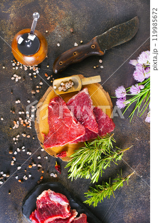 Juicy raw piece of meat on a wooden board 119985672