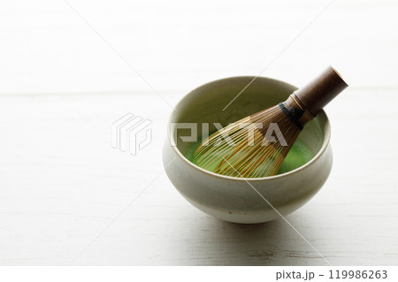 Cup of fresh matcha tea on white wooden table. 119986263
