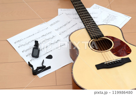 アコースティックギター・カポタスト・楽譜と音楽イメージ アコースティックギター・カポタスト・楽譜と音楽イメージ 119986480