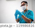 Medical Professional Preparing Syringe with Protective Mask and Gloves 119986816