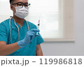Healthcare Worker Holding Syringe in Preparation for Injection 119986818