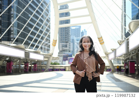 Confident mature businesswoman posing in modern cityscape 119987132