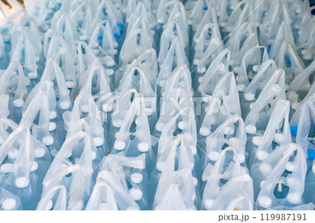 Many packaged water bottles in plastic bags prepared for donation to flood victims at the distribution center, supplies for flood disaster relief. Many packaged water bottles in plastic bags prepared for donation to flood victims at the distribution center, supplies for flood disaster relief. 119987191