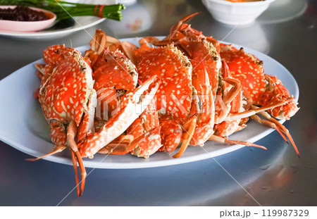 Fresh sea crabs cooked by charcoal grilling, served on the dish with Thai seafood dipping sauce at the famous local restaurant in Thailand. 119987329