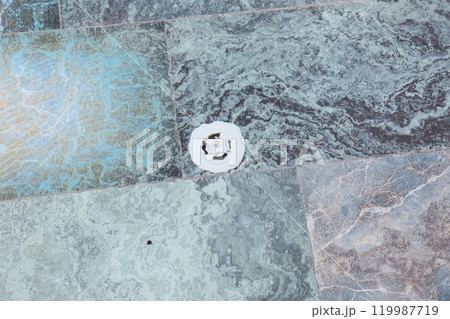 Exquisite Textured Stone Floor Featuring a Stylish Circular Drain Cover in its Design 119987719