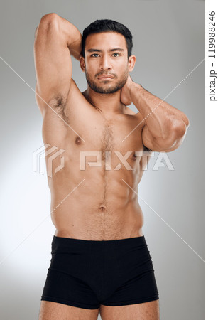 Studio portrait, man and body muscle development for fitness with exercise aesthetic and results for sport. Shirtless, stripper guy and strong abdomen with abs for sensual figure by grey background 119988246