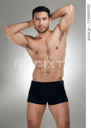 Portrait, body and man in studio for muscle development with exercise aesthetic and results for sports. Shirtless, bodybuilder guy and stomach with strong abs and training wellness by grey background 119988300