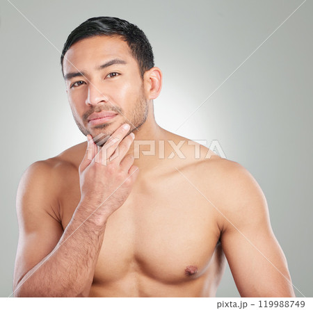 Skincare, beauty and portrait of man in studio with natural, health and wellness treatment for confidence. Cosmetic, hygiene and person with face dermatology for morning routine by gray background. Skincare, beauty and portrait of man in studio with natural, health and wellness treatment for confidence. Cosmetic, hygiene and person with face dermatology for morning routine by gray background. 119988749