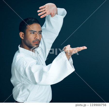 Karate, training and man in martial arts on studio, black background and practice exercise. Serious, fight and person with skill in self defence technique, action or fighter gesture with hands 119988756