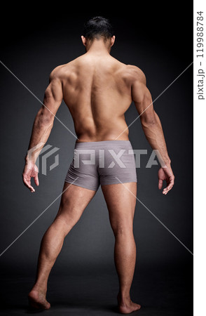 Man, underwear and body muscle for fitness, workout or training isolated on black background in studio. Back, bodybuilder and topless person with strong legs, feet and wellness for healthy exercise 119988784