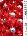 Background Silver mirror disco balls toys and lights on red indoor Christmas tree for New Year 119988807