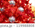 Silver mirror disco balls toys and lights on red indoor Christmas tree for new year 119988808