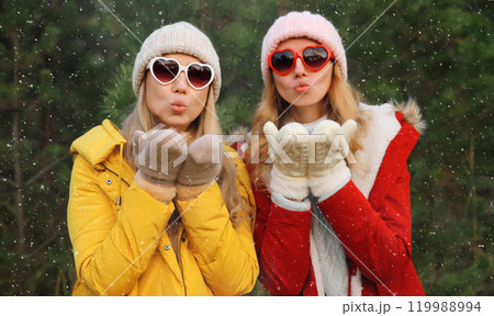 Happy women friends having fun, celebration, girlfriends on Christmas tree in winter with snow Happy women friends having fun, celebration, girlfriends on Christmas tree in winter with snow 119988994