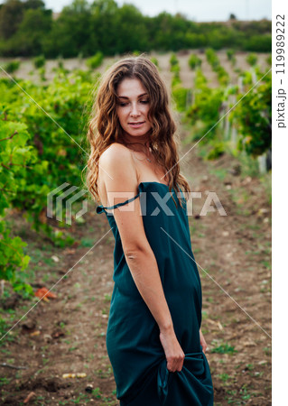 Beautiful woman walking in vineyard before harvest Beautiful woman walking in vineyard before harvest 119989222