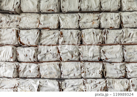 The natural Thai standard rubber bales sheet products staked and stored in the factory warehouse. The storage procession product of a rubber factory. 119989324