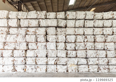 The natural Thai standard rubber bales sheet products staked and stored in the factory warehouse. The storage procession product of a rubber factory. 119989325