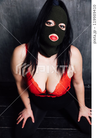 Portrait of a beautiful woman in red lingerie and black mask 119989410