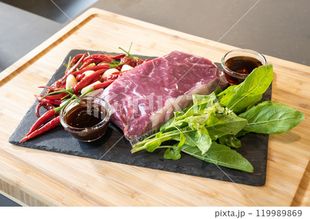 Close up, Raw Beef herb ingredients, basil, garlic, chilli, sauces are prepared on black slate plate for cooking Thai food menu, Stir-fried beef basil. 119989869