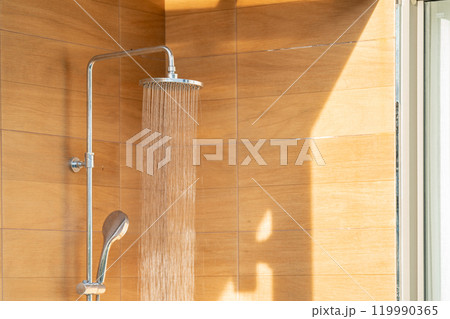 Outdoor shower head for the bath and showering cold water to body before jumping in the resort pool. 119990365
