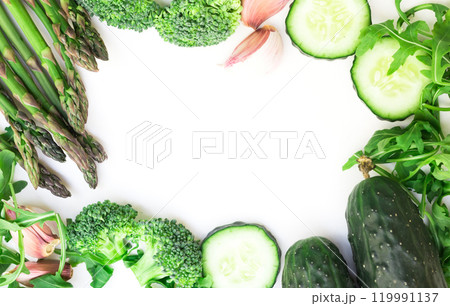 Frame of green vegetables broccoli, arugula, cucumber, asparagus and garlic on white background Frame of green vegetables broccoli, arugula, cucumber, asparagus and garlic on white background 119991137