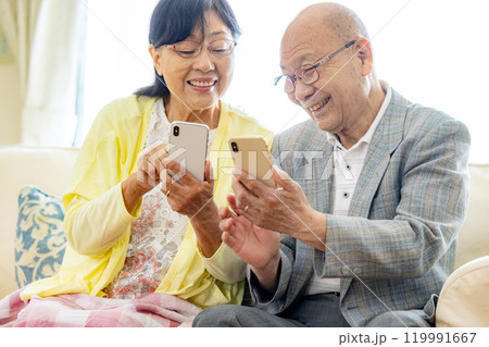 スマホを操作するシニア夫婦 スマホを操作するシニア夫婦 119991667