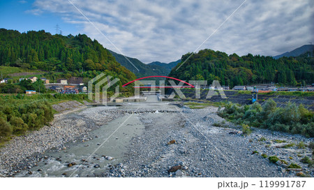 秋の黒部川にかかる赤い愛本橋周辺の風景 119991787